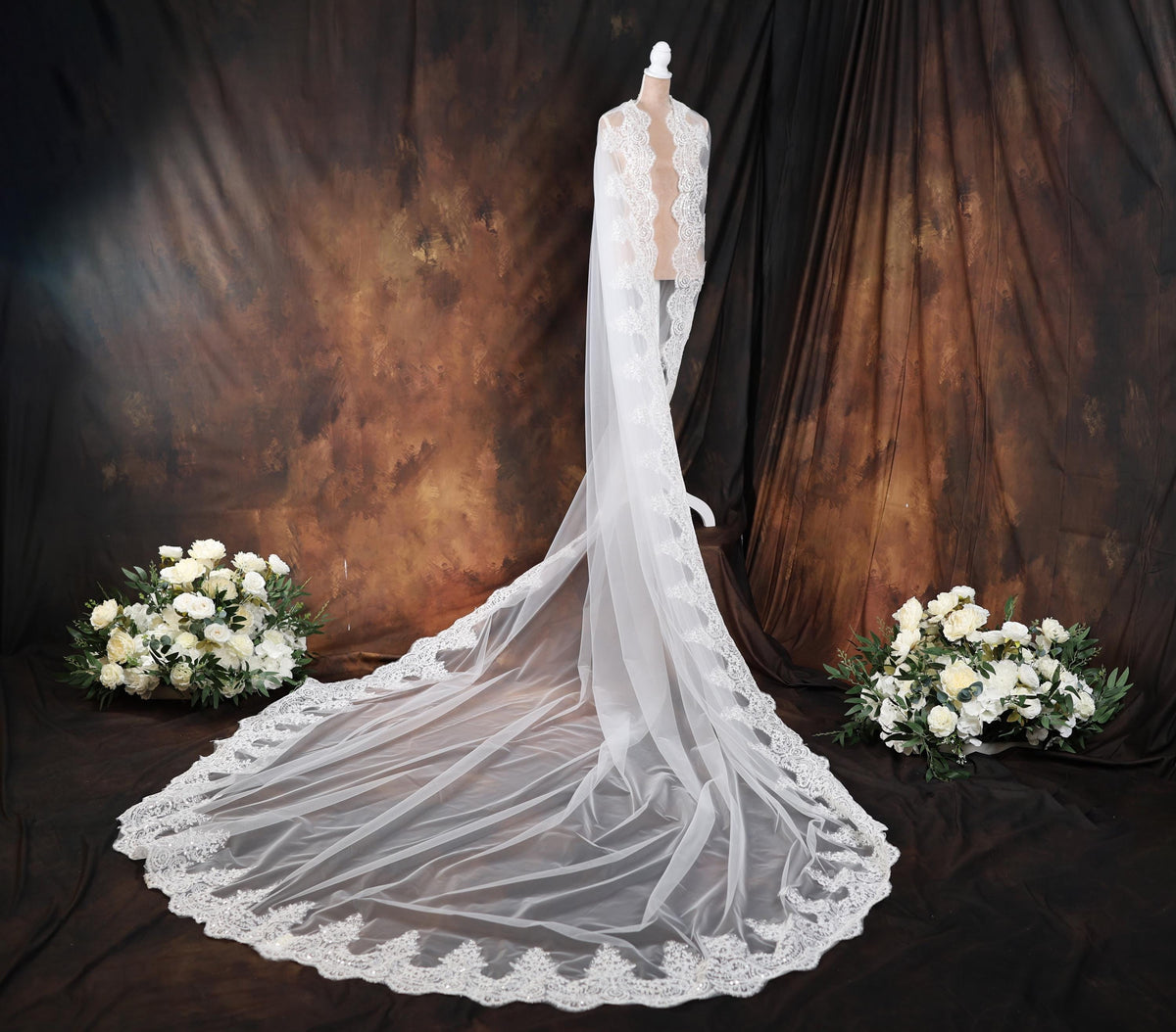 a wedding dress with a veil on a mannequin