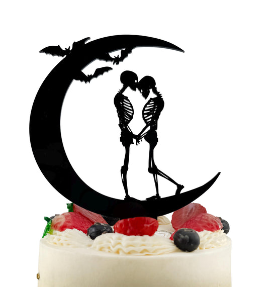 A black silhouette of a skeleton couple embracing on a crescent moon, with bats flying above them, is the central focus of the image.