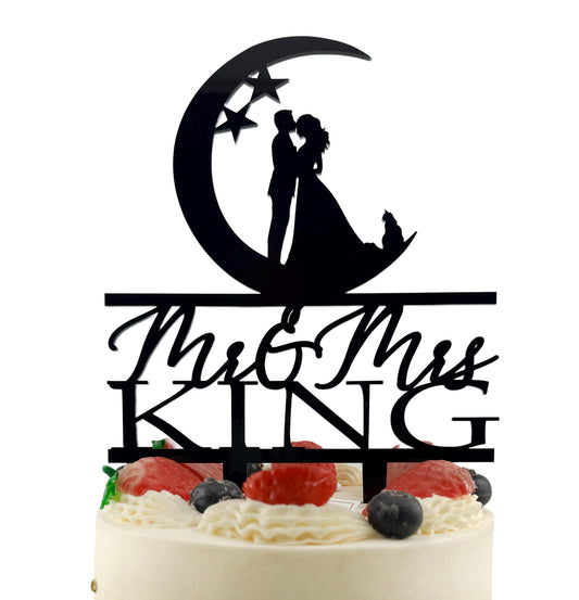 A black silhouette of a bride and groom on a crescent moon and stars, with the words "Mr & Mrs" written below.