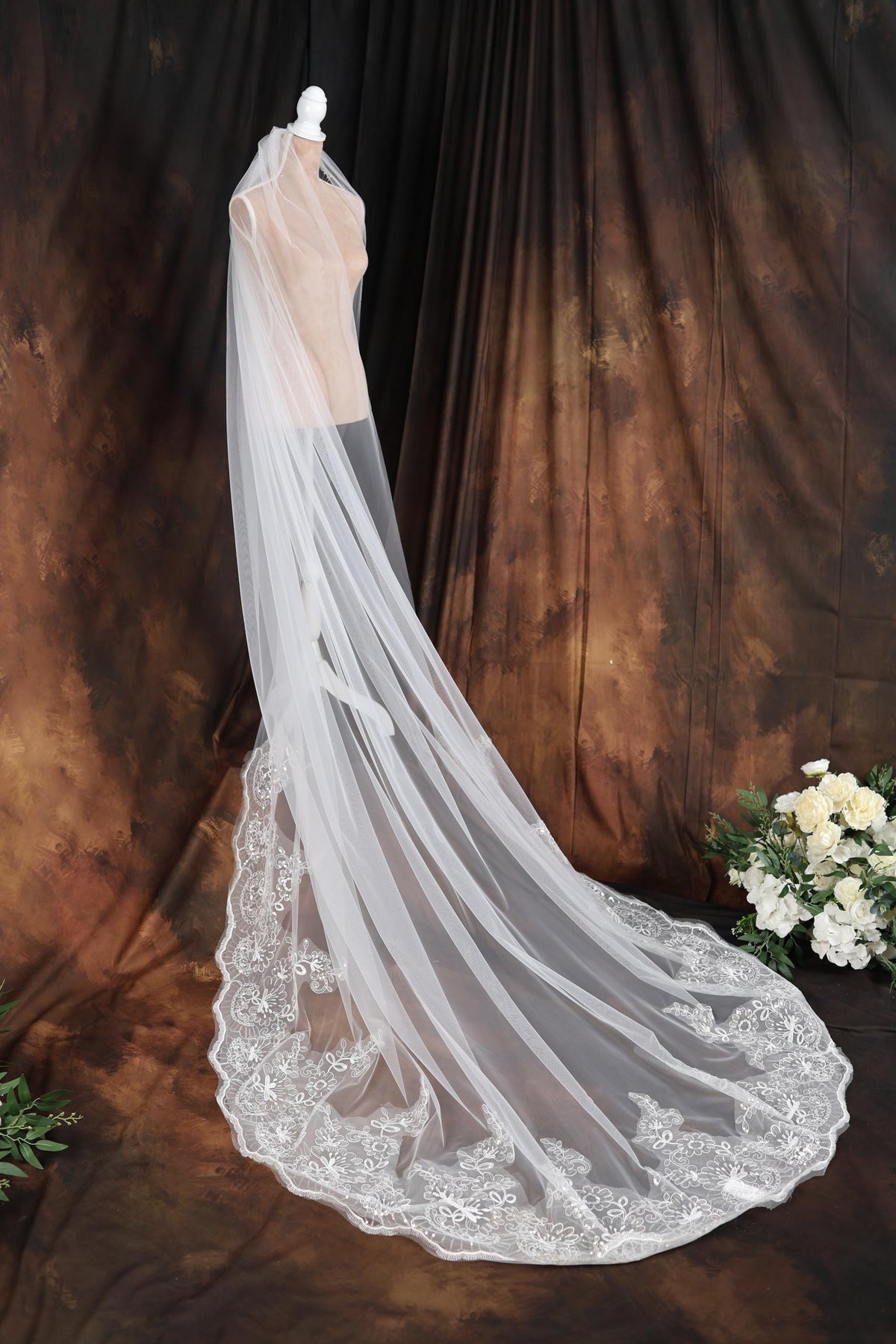 a wedding veil on a mannequin in front of a backdrop
