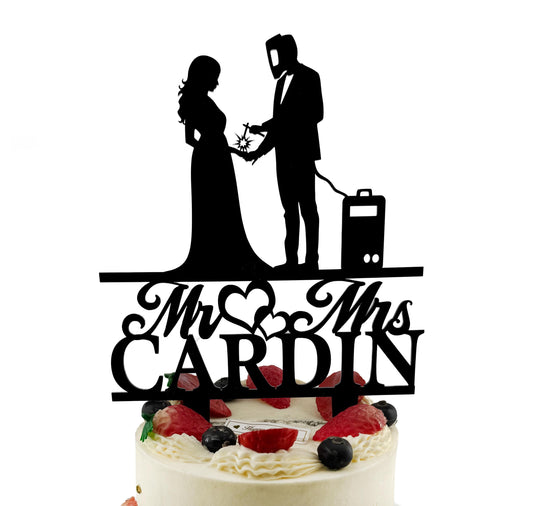 A silhouette of a bride and groom on a wedding cake topper, with the text "Mr. CARDIN" below them.