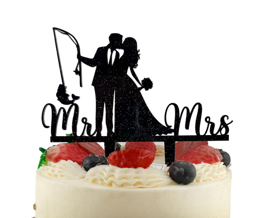 A black silhouette of a bride and groom on top of a cake, with the words "Mr. & Mrs." written below them.