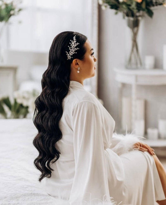 a woman sitting on top of a bed wearing a white dress