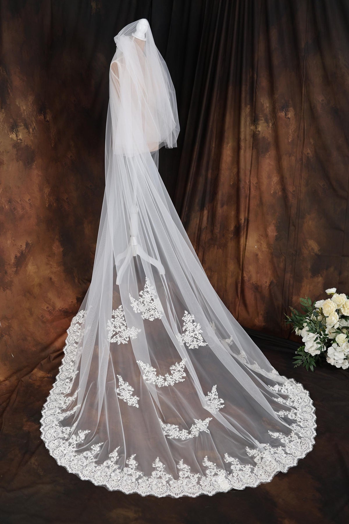 a bridal veil with white flowers on a table