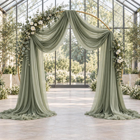 a beautifully decorated wedding arch with a green and white floral arrangement, set against a backdrop of a large glass-walled room with greenery.