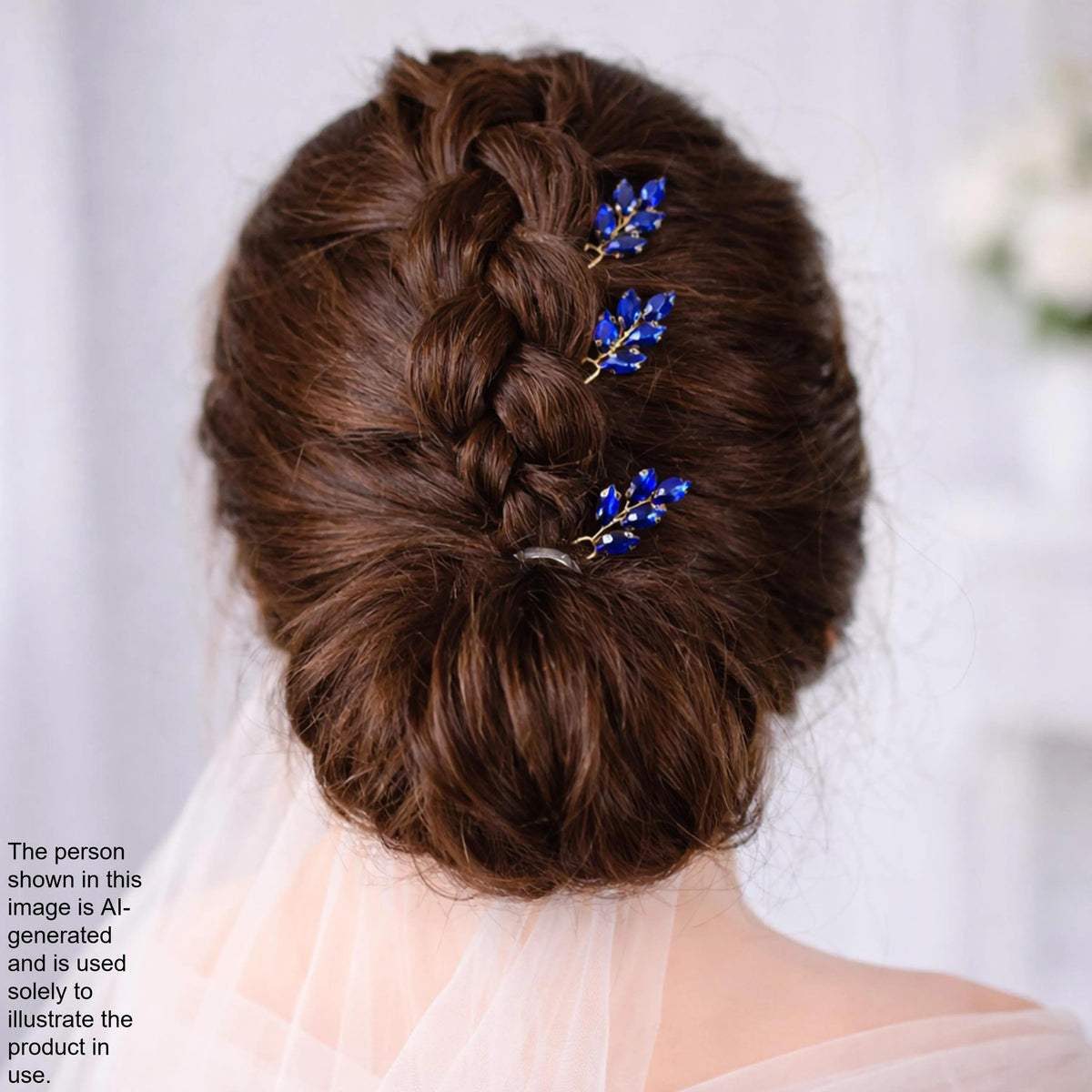 a woman's back view with her hair styled in a bun and adorned with blue floral hair clips.