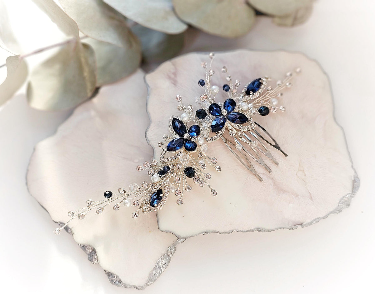 a blue and white hair comb sitting on top of a rock