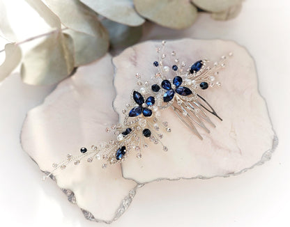 a blue and white hair comb sitting on top of a rock