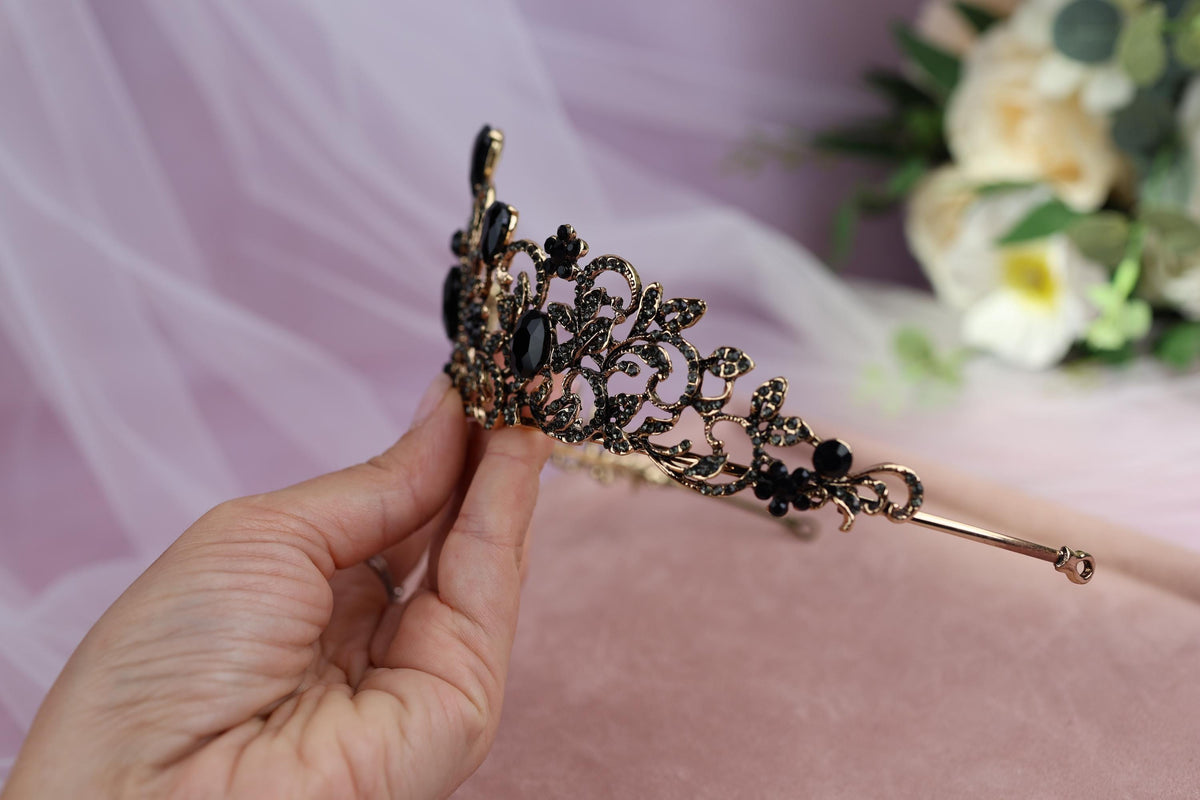 a hand holding a tiara with flowers in the background