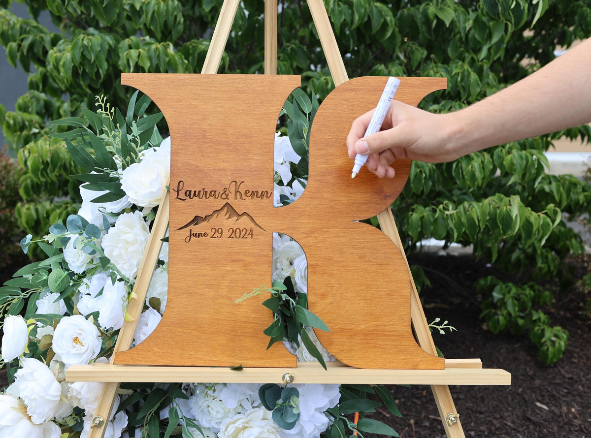 a person writing on a wooden easel with flowers in the background