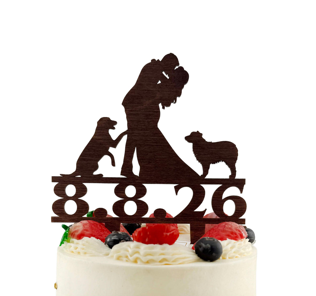 A silhouette of a couple embracing a dog on a cake topper with the number "8.8.8.26" displayed below it.