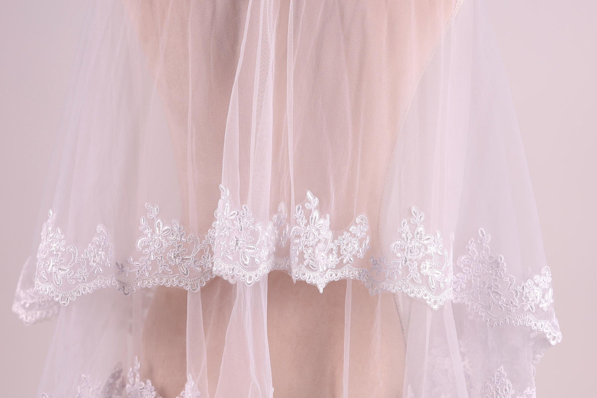 A close-up view of a delicate white wedding veil with intricate lace detailing.