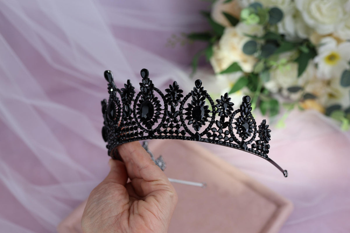 a woman is holding a tiara in her hand