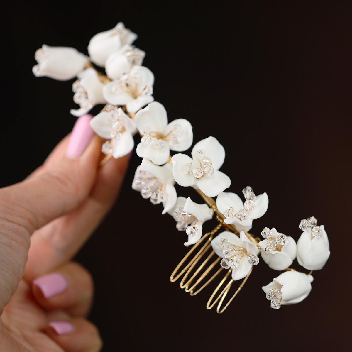 a hand holding a comb with flowers on it