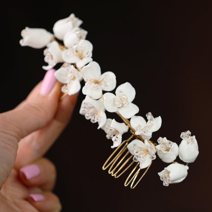 a hand holding a comb with flowers on it