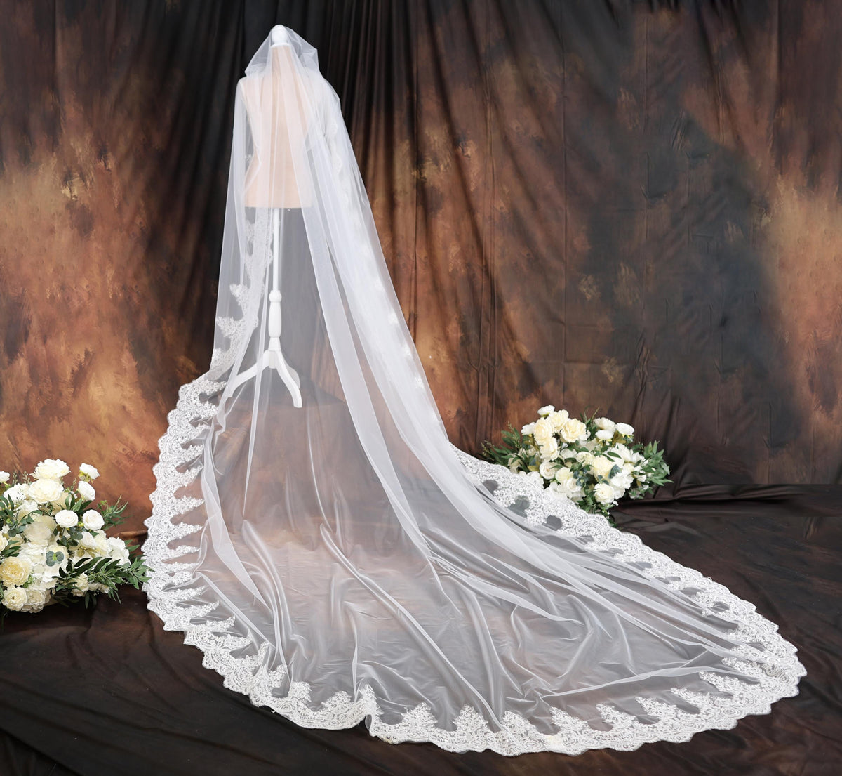 a wedding veil with a bouquet of flowers in front of it