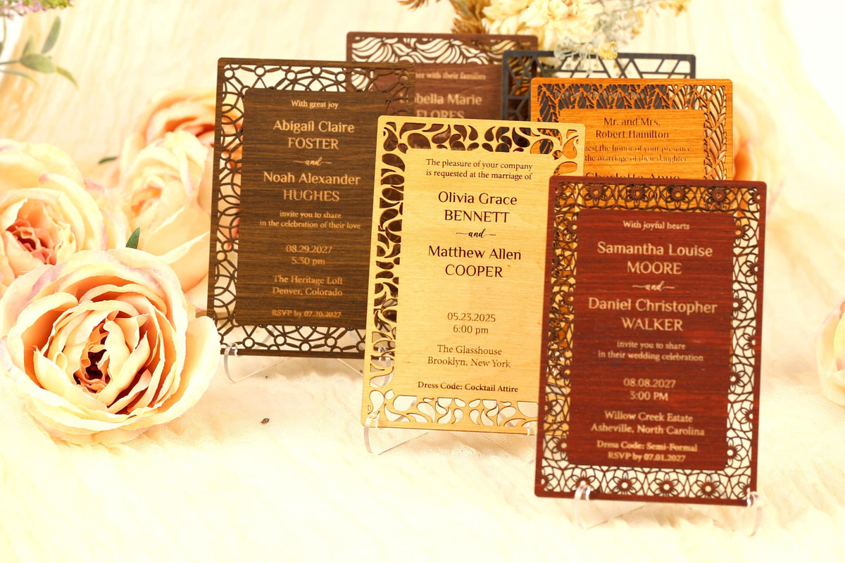 a collection of wedding invitations with intricate designs, placed on a table with flowers.