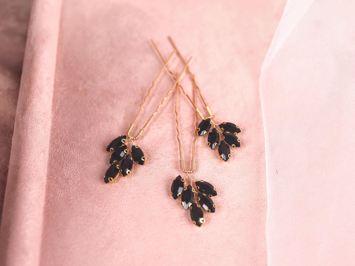 a close up of a pair of earrings on a pink cloth