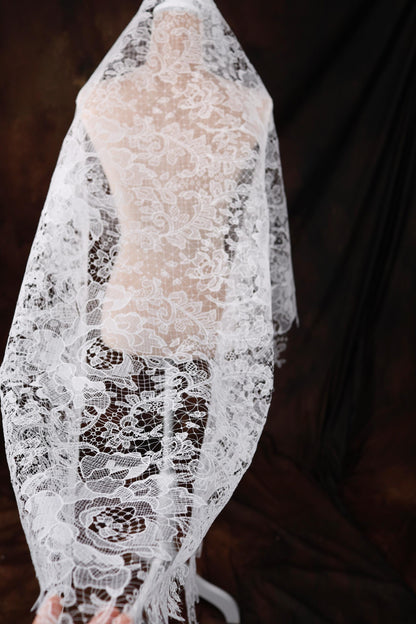 a woman wearing a white veil and a white dress