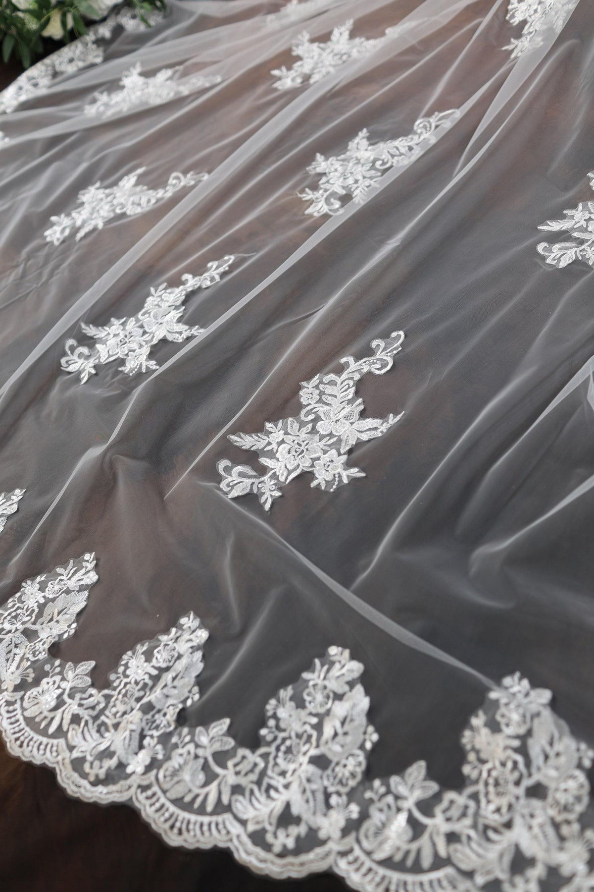 a wedding veil with white flowers on it