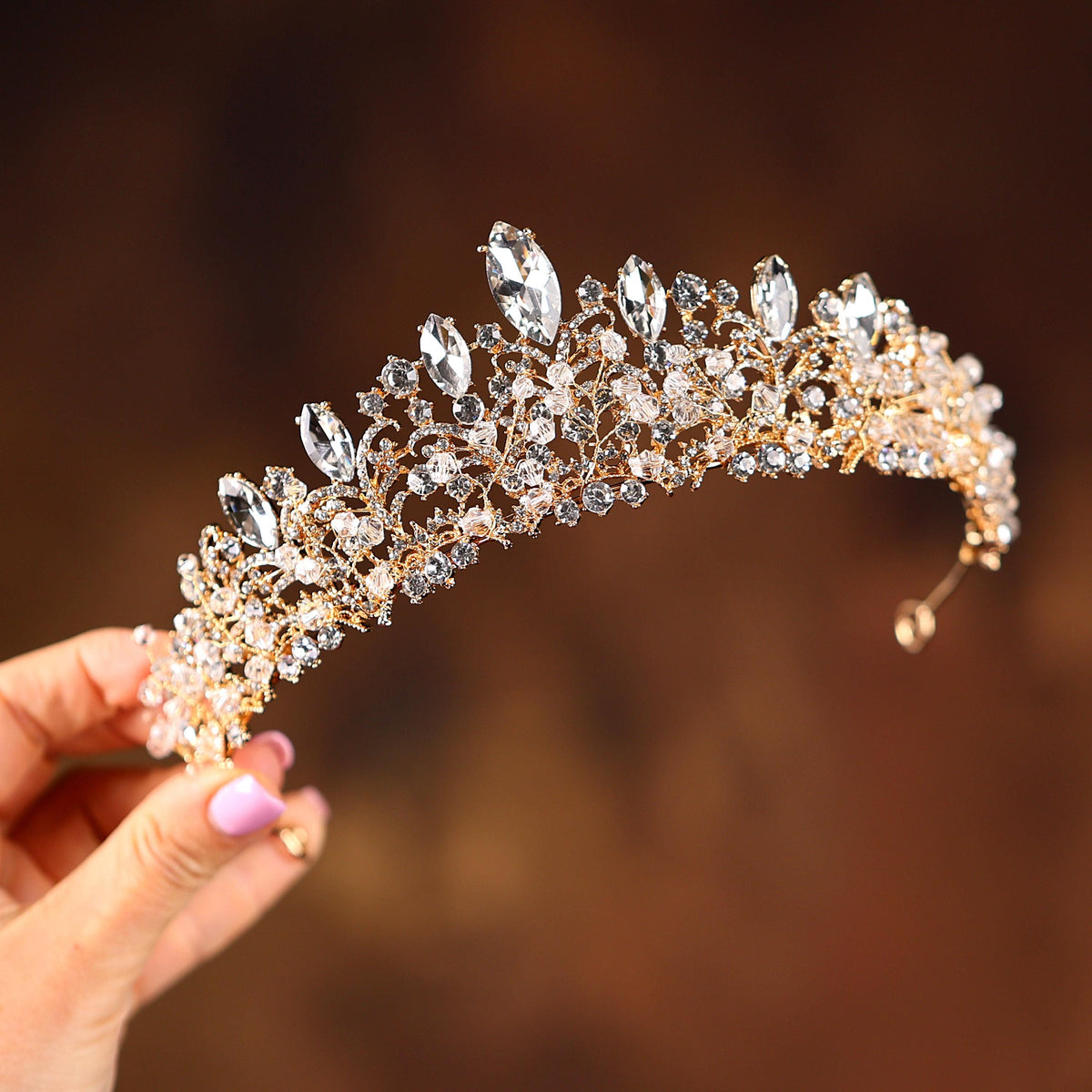 a woman holding a tiara in her hand