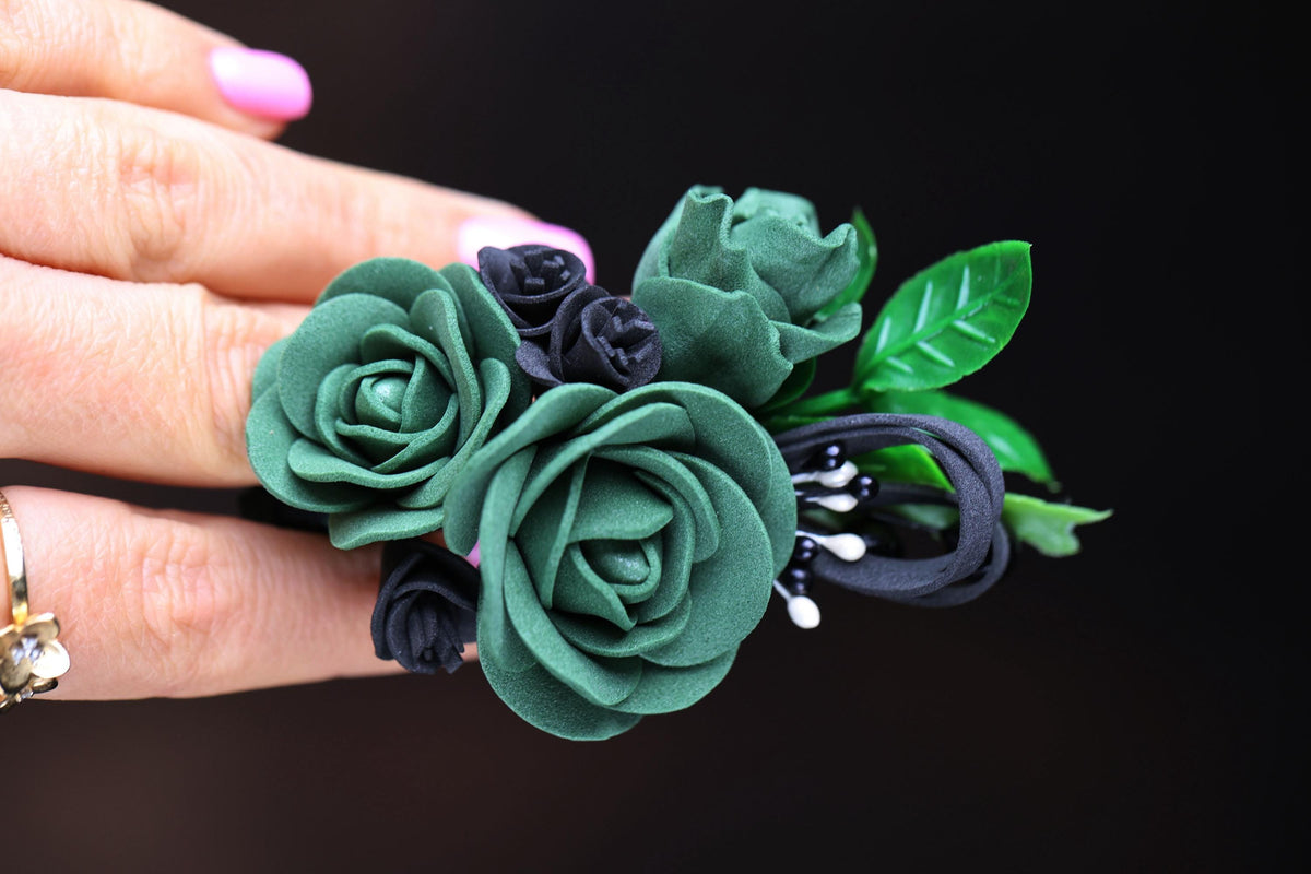 a woman's hand holding a ring with flowers on it