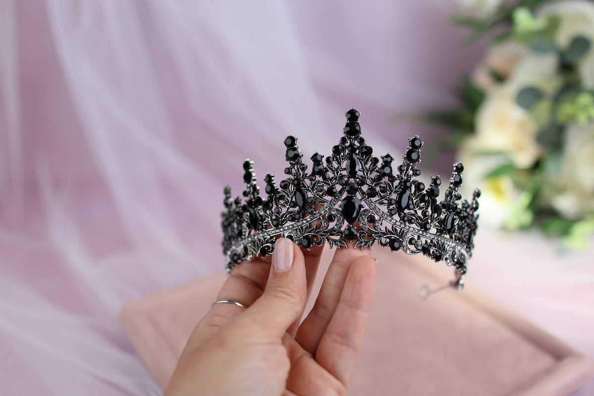 a woman is holding a tiara in her hand
