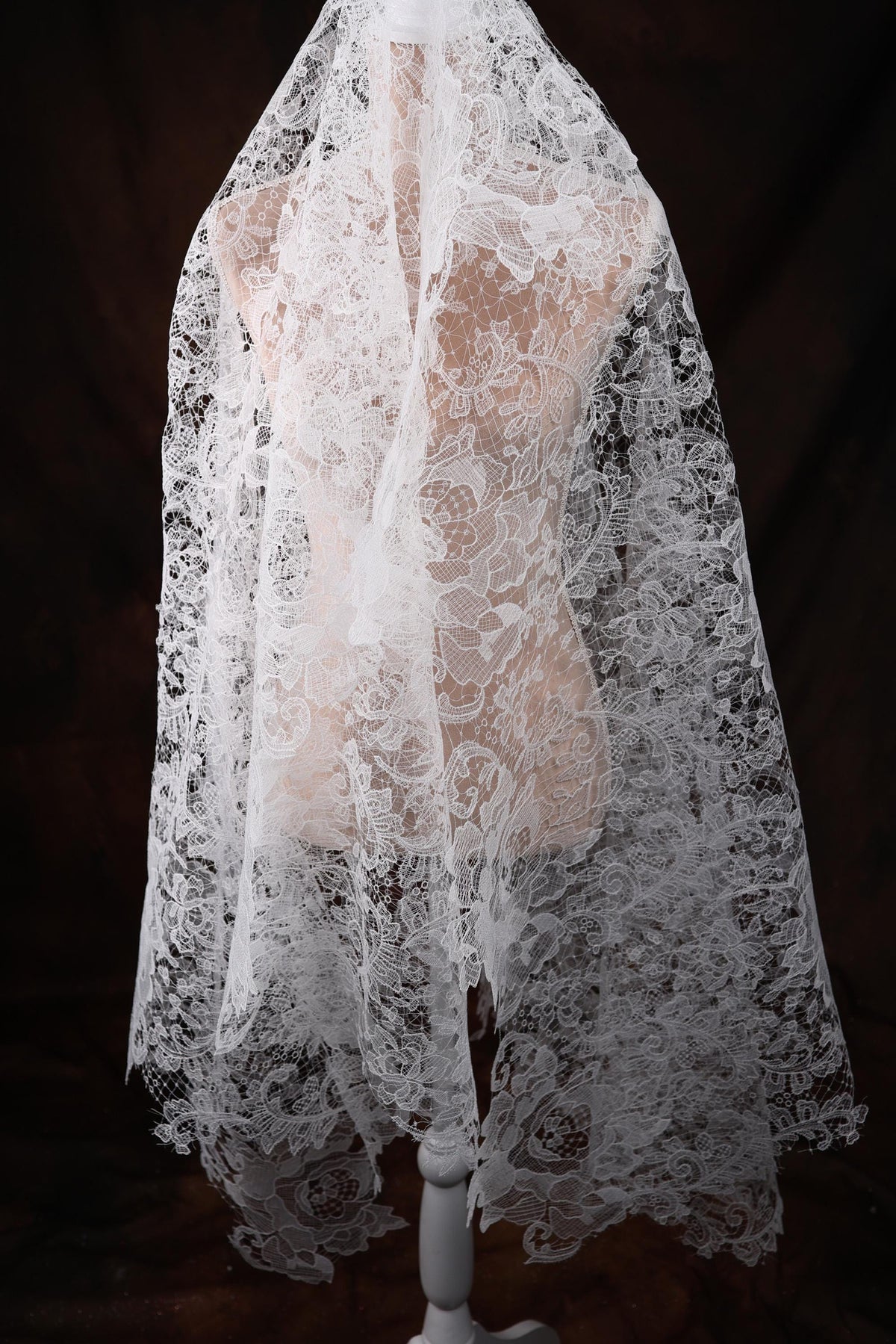 a mannequin wearing a white lace veil