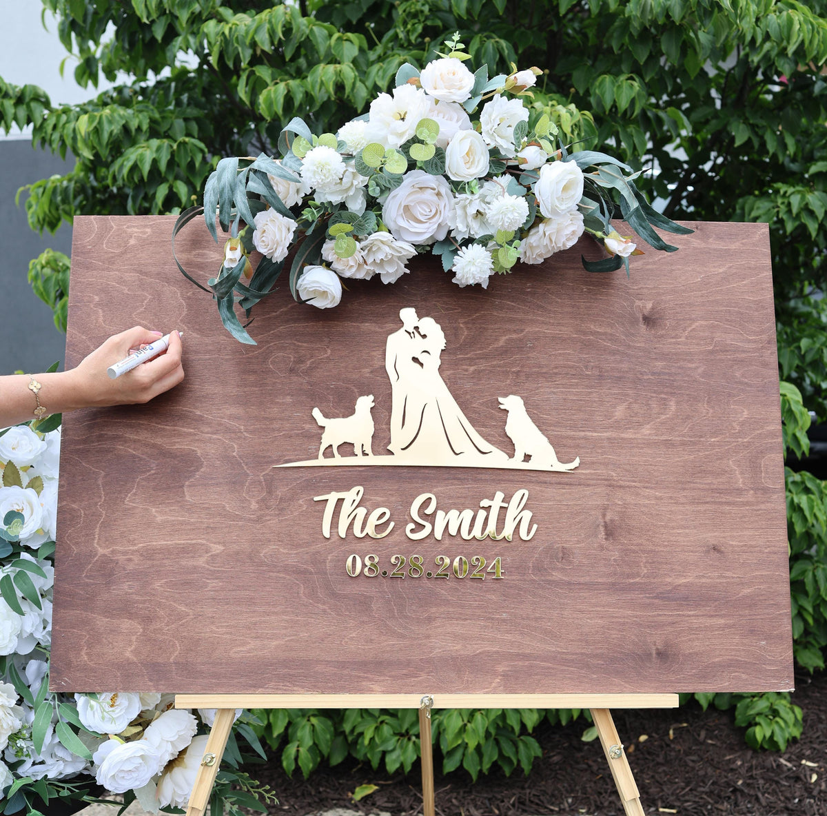 a wooden sign with a picture of a bride and groom and two dogs