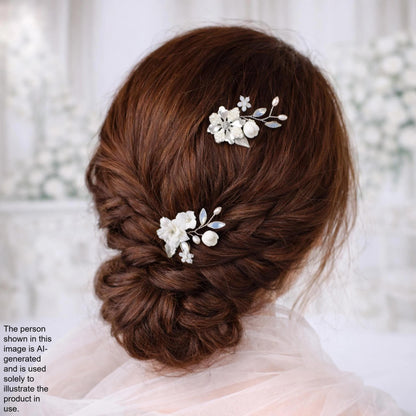 a woman's hair styled in a bun, adorned with two flower hair clips.