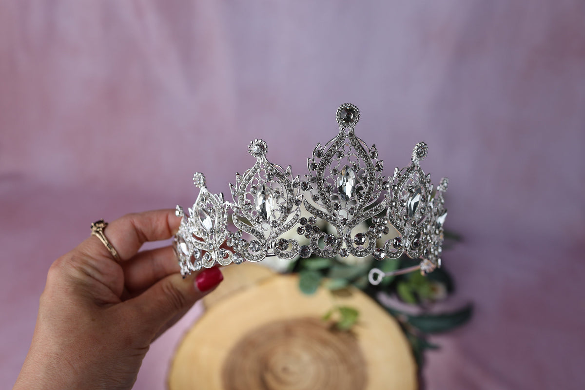 a woman is holding a tiara in her hand