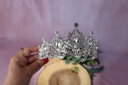a woman is holding a tiara in her hand