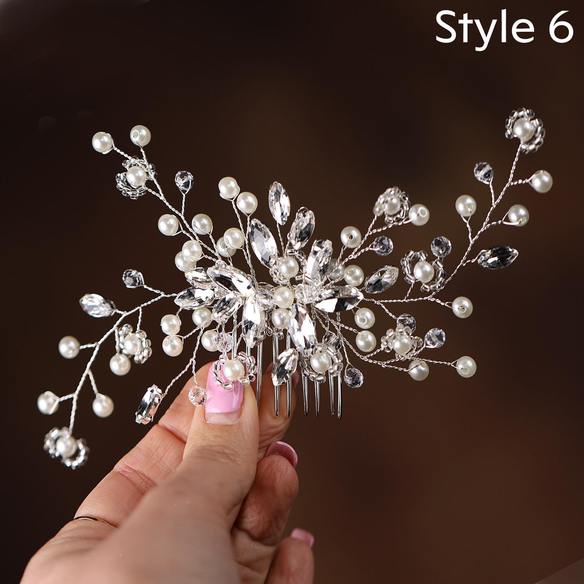 a woman is holding a hair comb with pearls on it