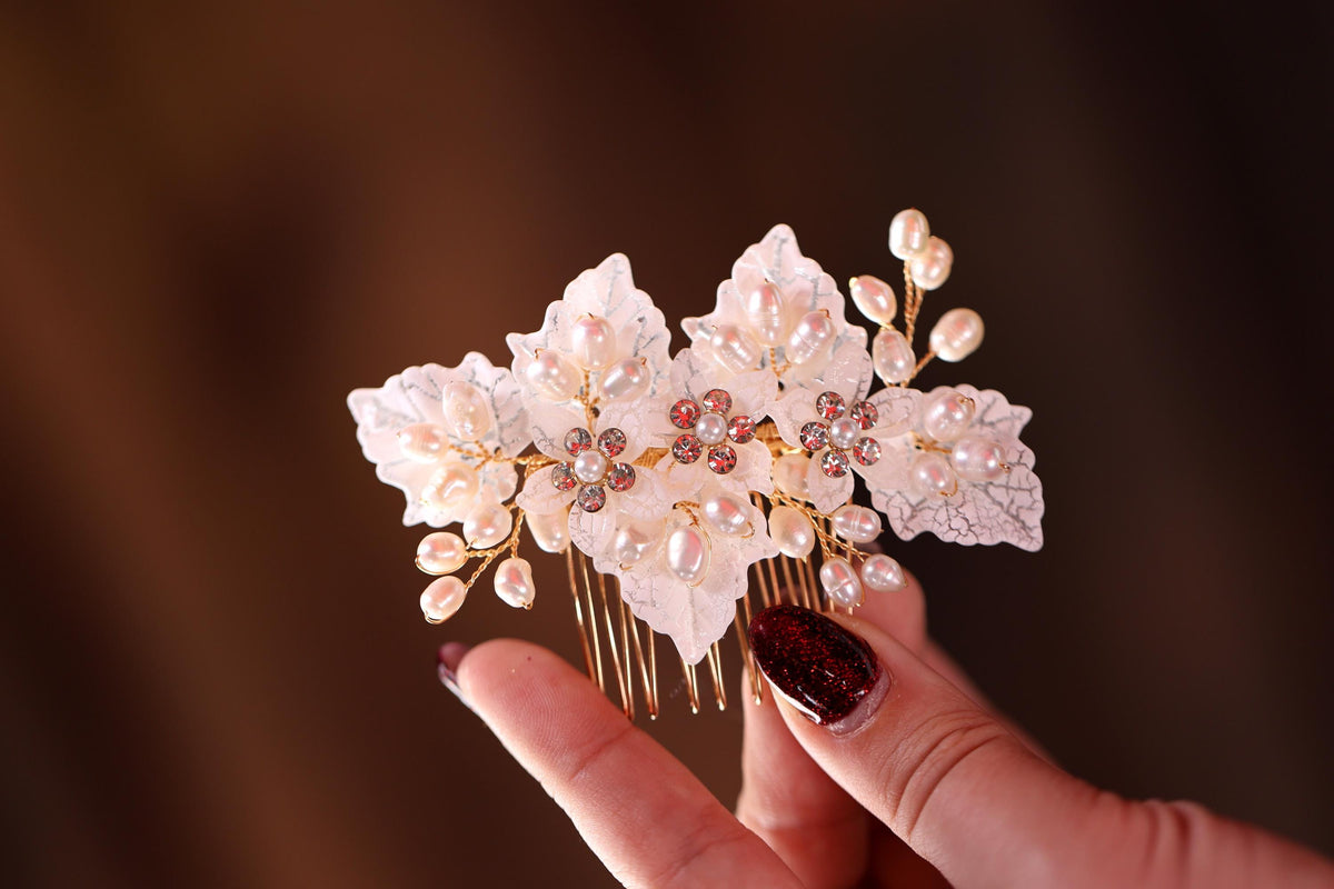a hand holding a hair comb with flowers on it