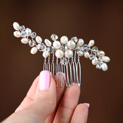 a woman's hand holding a hair comb with pearls on it
