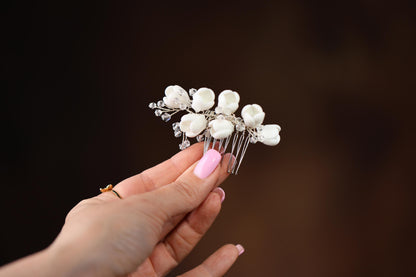 a woman holding a white flower hair comb