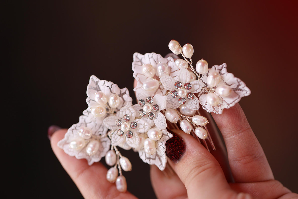 a hand holding a hair comb with flowers on it