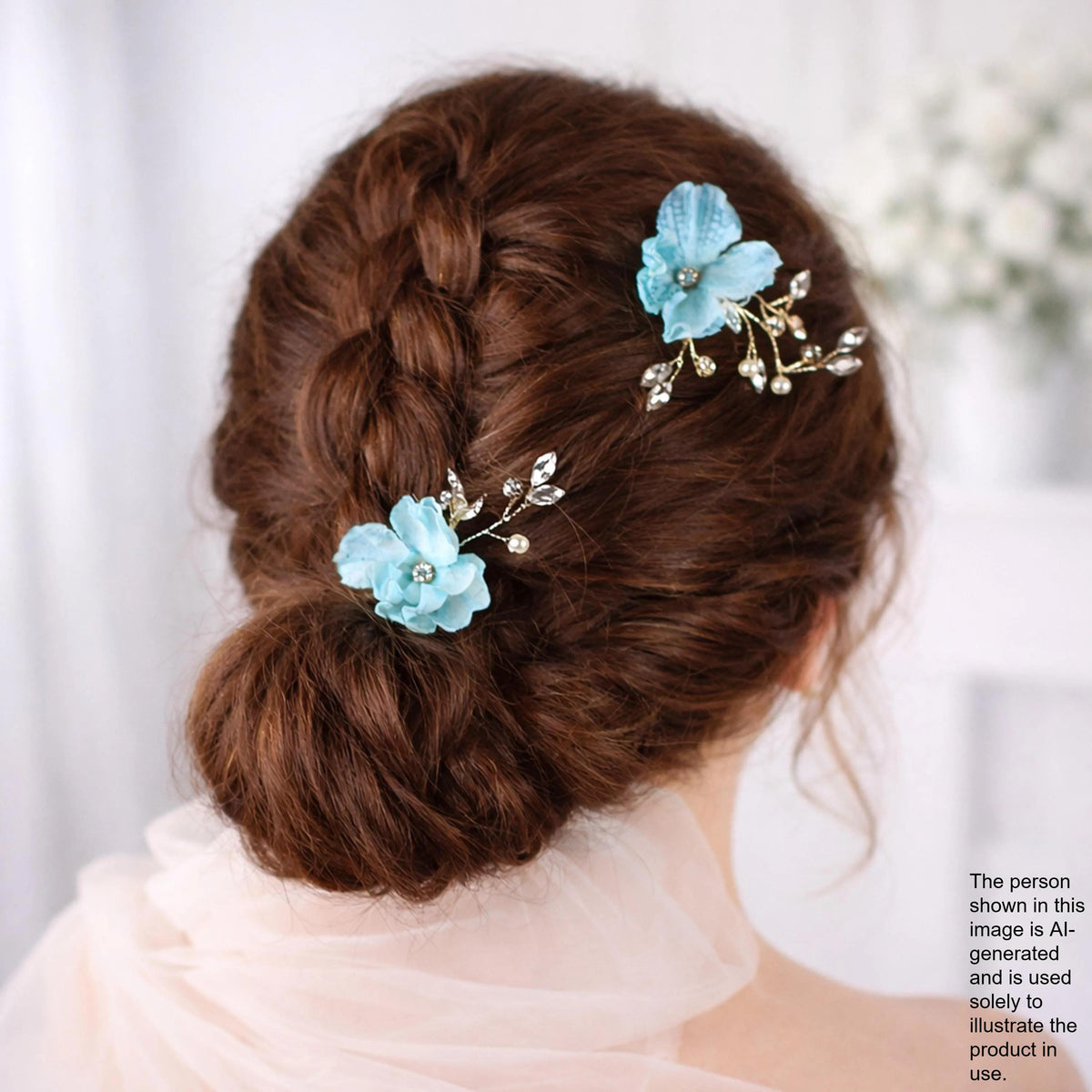 the back view of a woman's head with her hair styled in a bun, adorned with two blue flower hair clips.