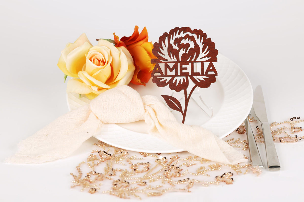 a white plate with a floral design, a bouquet of roses, and a nameplate with a flower design.
