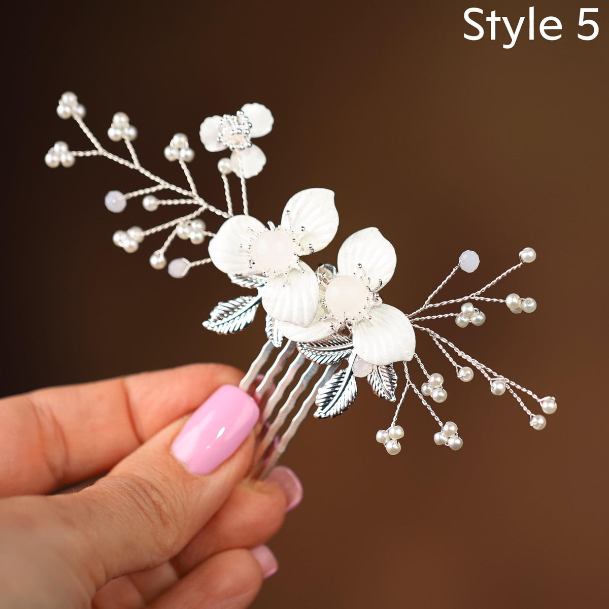 a hand holding a hair comb with flowers on it