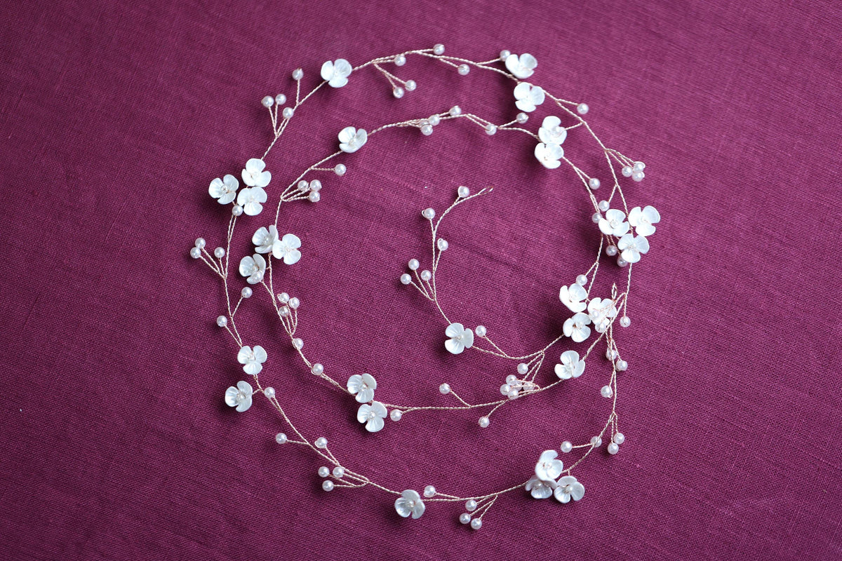 a necklace with white flowers on a purple background
