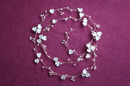 a necklace with white flowers on a purple background