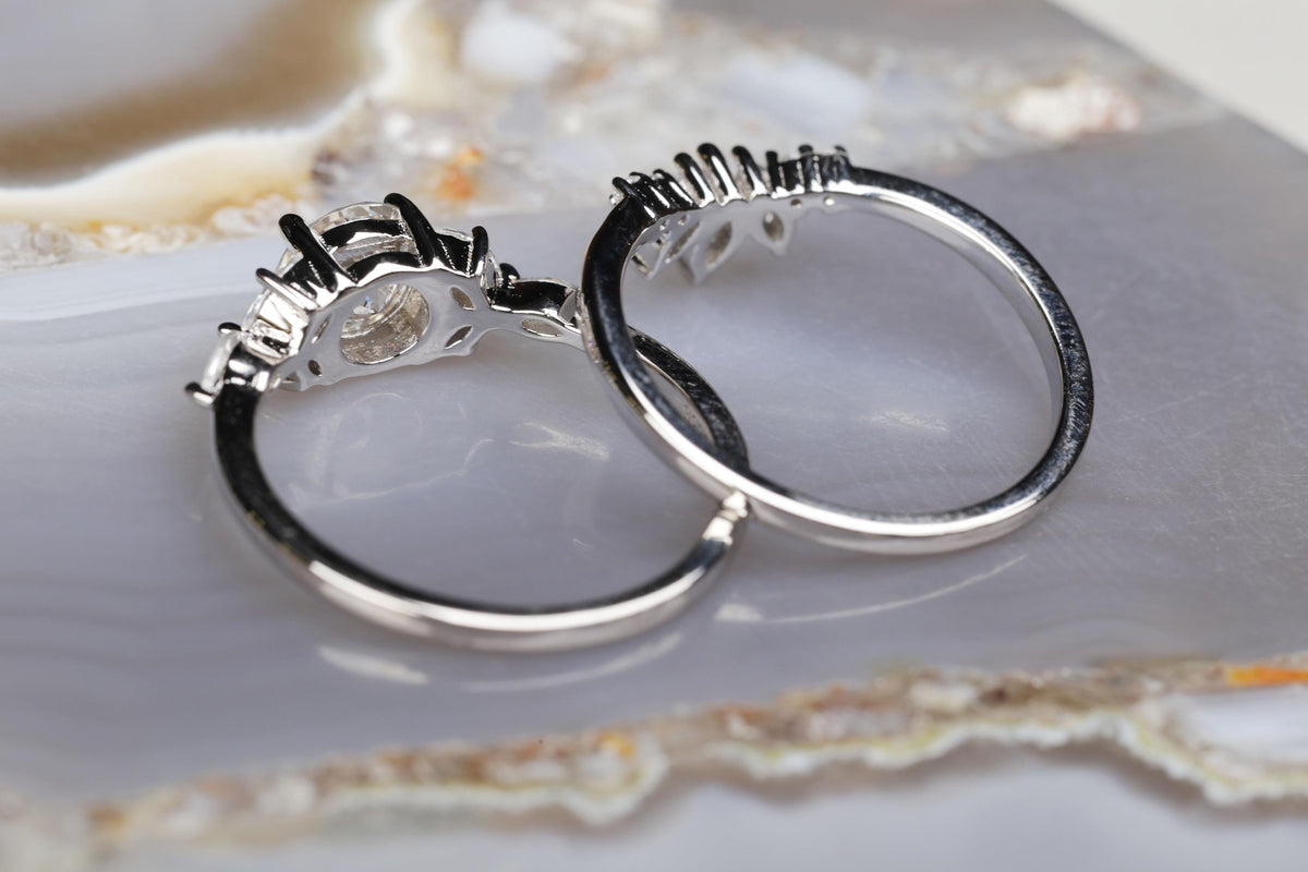 a couple of silver rings sitting on top of a white plate