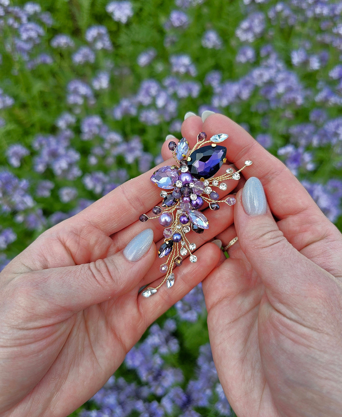 a woman's hands holding a ring with a flower on it