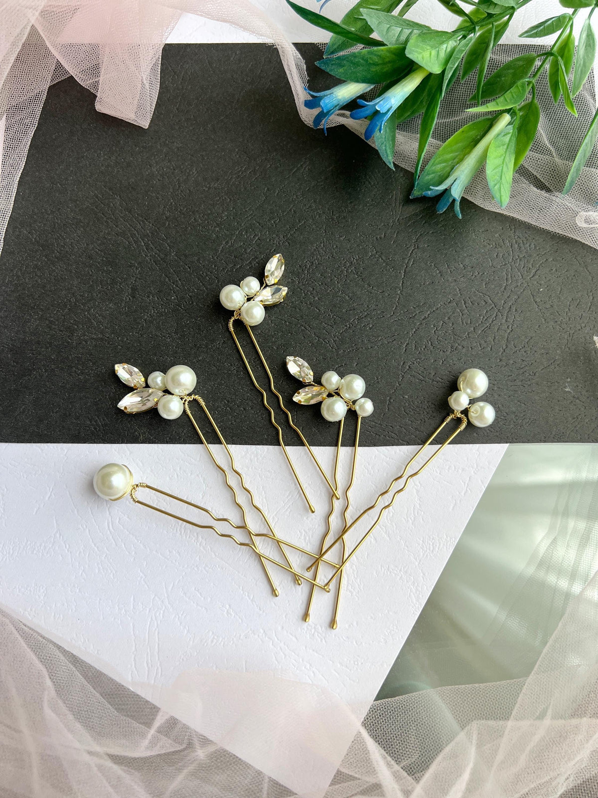 a close up of three hair pins on a table