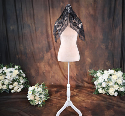 a white mannequin with a black scarf on top of it