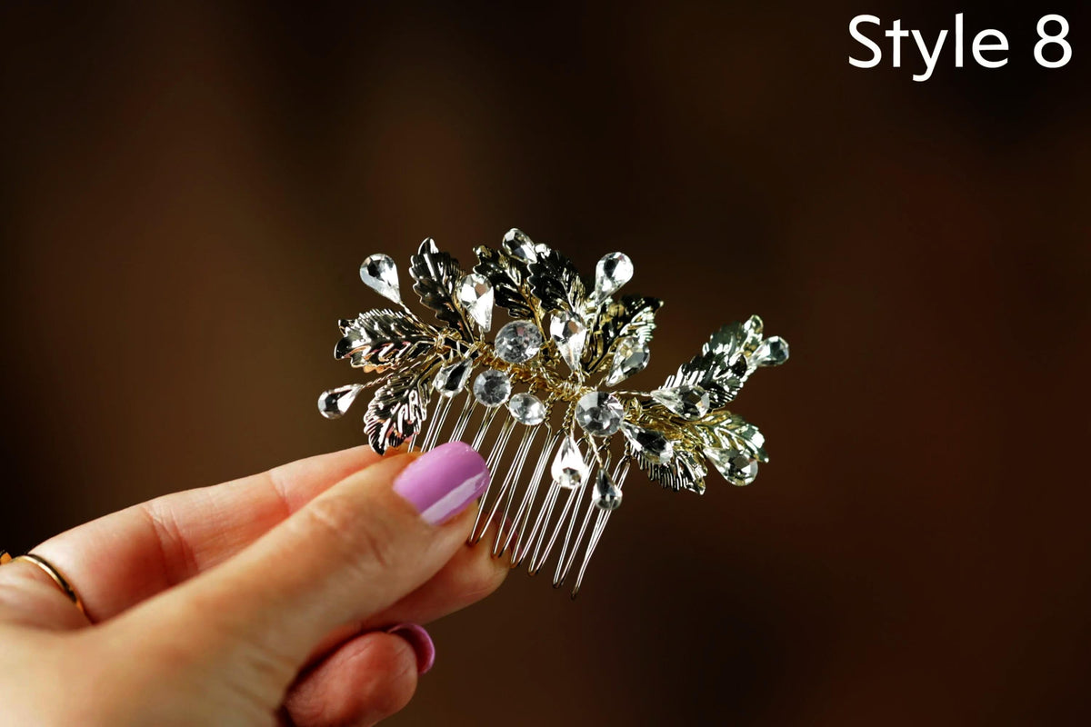 A hand holding a decorative hair accessory with a floral design and sparkling crystal elements.