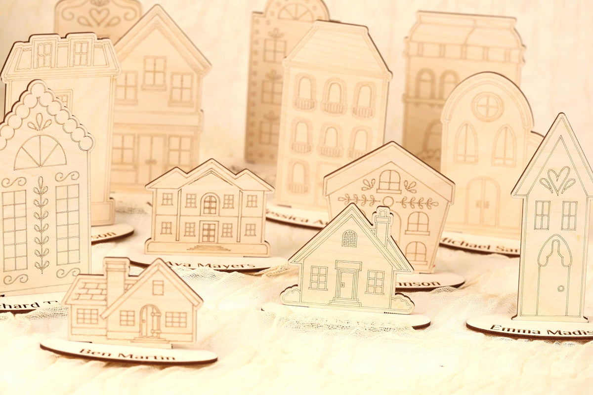 a collection of wooden houses, each with unique designs and decorations, arranged on a surface.