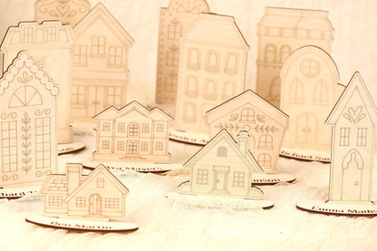 a collection of wooden houses, each with unique designs and decorations, arranged on a surface.