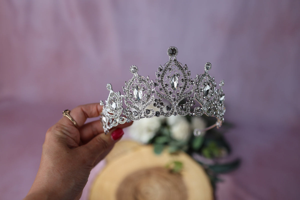 a woman is holding a tiara in her hand
